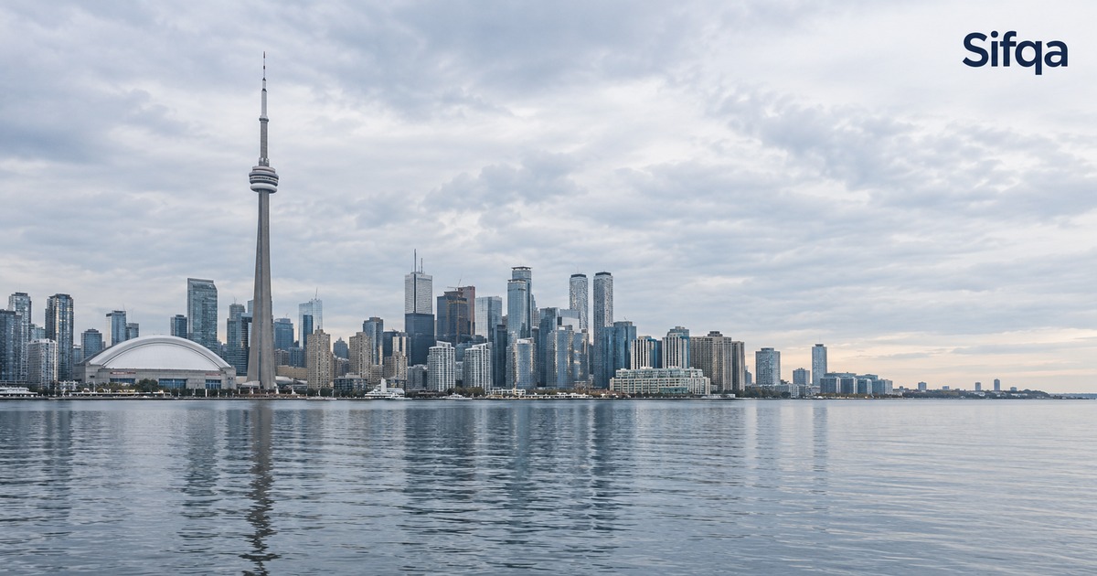The Toronto skyline with the CN Tower seen across the water under a cloudy sky.